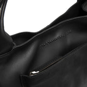 
Tenara Bolso de mano de cuero flor - Vista lateral mostrando el corte ergonómico de mangas